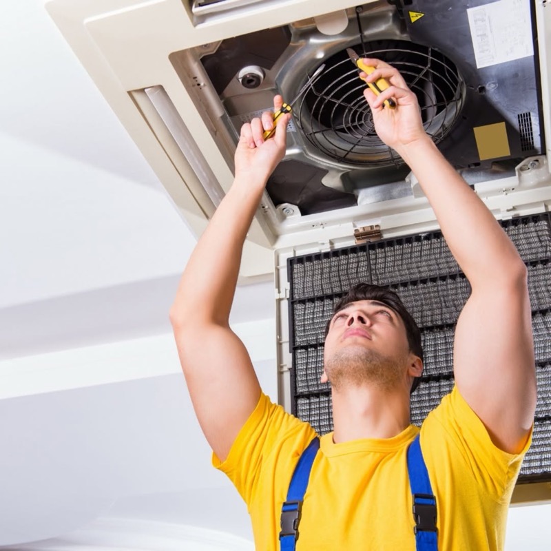 HVAC technician servicing a ceiling air conditioner — Tom's Heating & Air Conditioning, Van Buren, AR